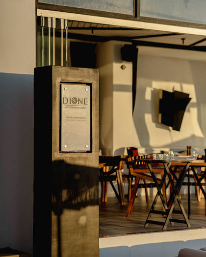 Grand Ambassador Dione restaurant entrance sign and modern dining area in afternoon light