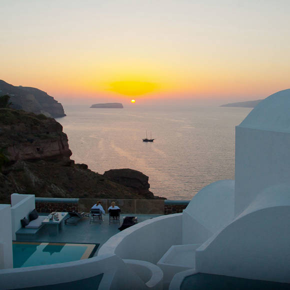 Sunset view over the sea from Grand Ambassador hotel terrace with two people seated by a pool