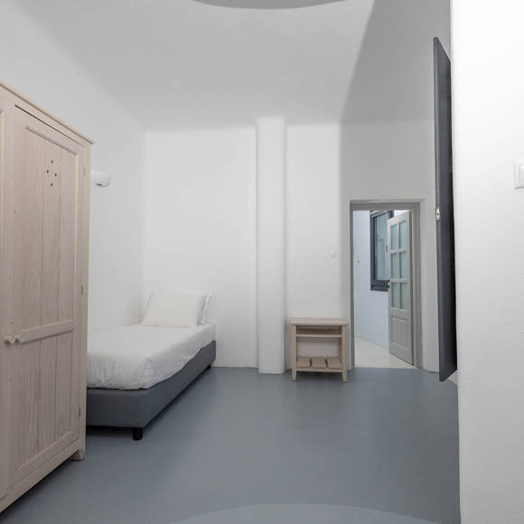 Grand Ambassador Santorini Serenity Two Bedroom Suite single guest room with built-in wardrobe and minimalist decor