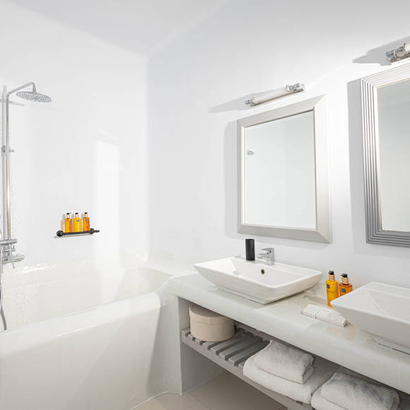 Grand Ambassador Santorini Serenity Two Bedroom Suite bathroom with built-in tub, twin sinks, rainfall shower, and luxury amenities